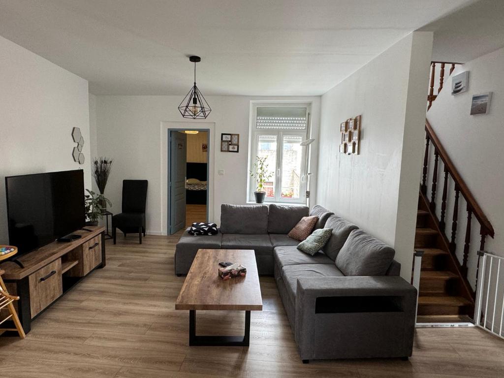 a living room with a couch and a tv at L'APPARTEMENT BOULONNAIS in Boulogne-sur-Mer