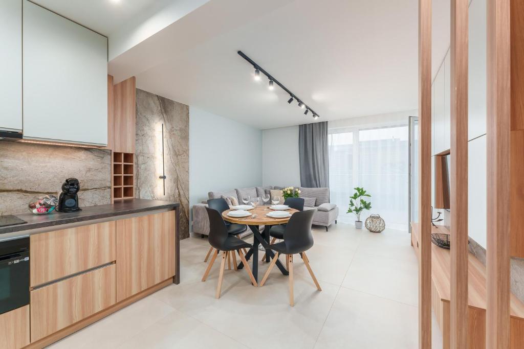 una cucina e un soggiorno con tavolo e sedie di RICAR Apartament Klifowa Rewal a Rewal