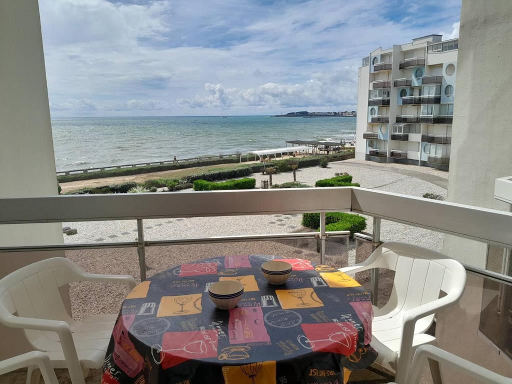 une table sur un balcon avec vue sur la plage dans l'établissement Saint Gilles - T3 Face Mer avec Balcon, Parking Privé, Accès Direct Plage - FR-1-324-543, à Saint-Gilles-Croix-de-Vie