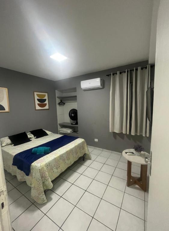 Un dormitorio con una cama con un edredón azul. en Apartamento no Derby, en Recife