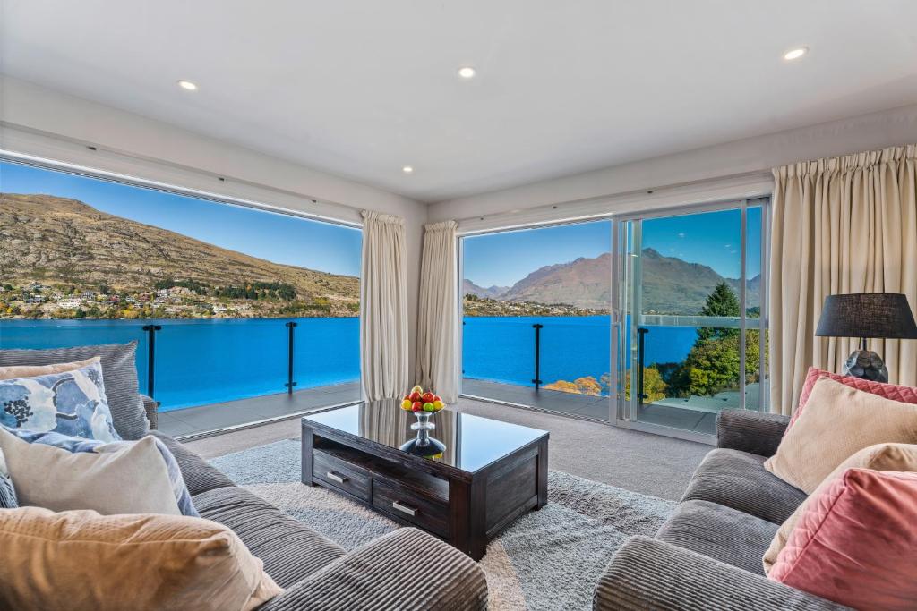 a living room with a view of the water at Lakefront Penthouse Apartment with 270-degree view in Queenstown