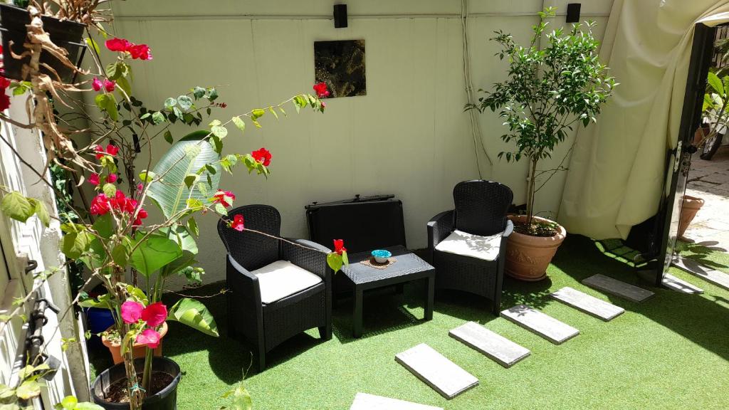a patio with two chairs and a table and some plants at Garden Suite Apartment in Palermo