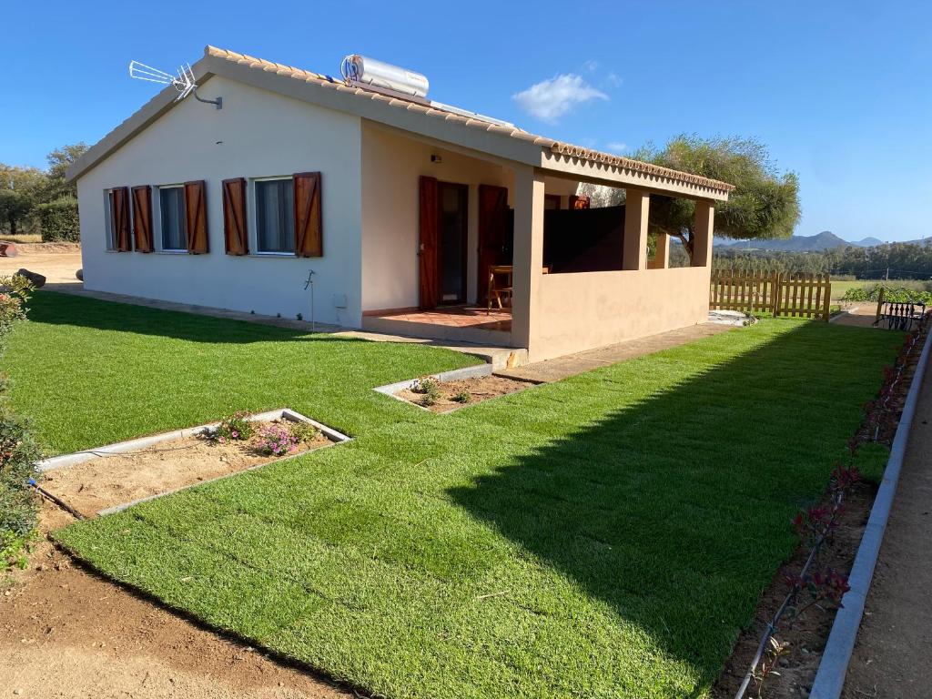 a small white house with a large yard at La Collina: Il tramonto in Castiadas