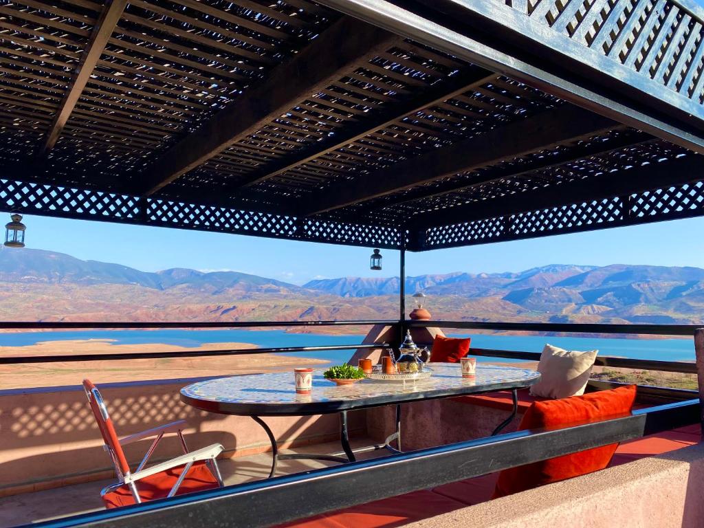 a table on a balcony with a view of the desert at petite jolie maison vue sur lac in Bine el Ouidane