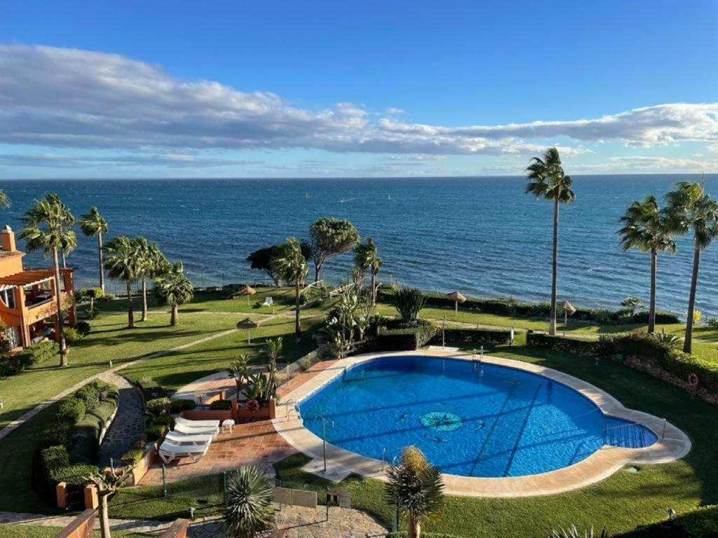 een zwembad met de oceaan op de achtergrond bij Apartment Los Molinos on the beachfront with pool in Estepona