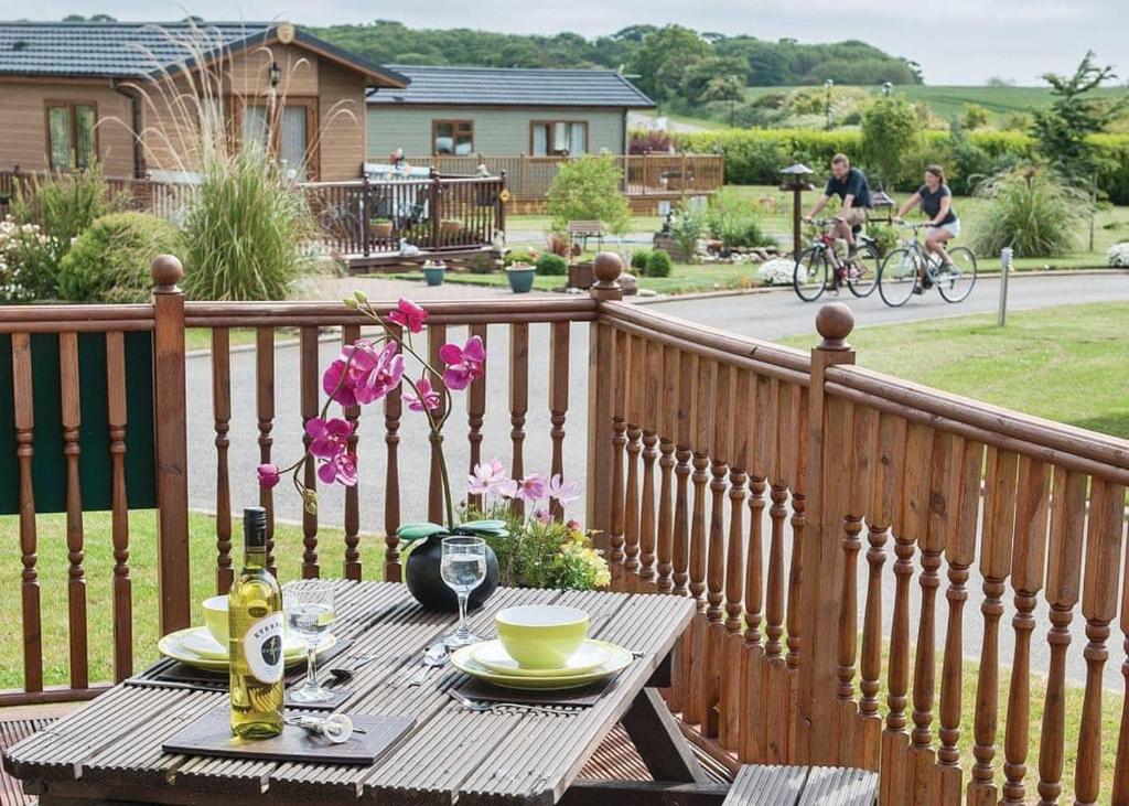 a wooden table with plates and drinks on a balcony at Holderness Country Park in Tunstall