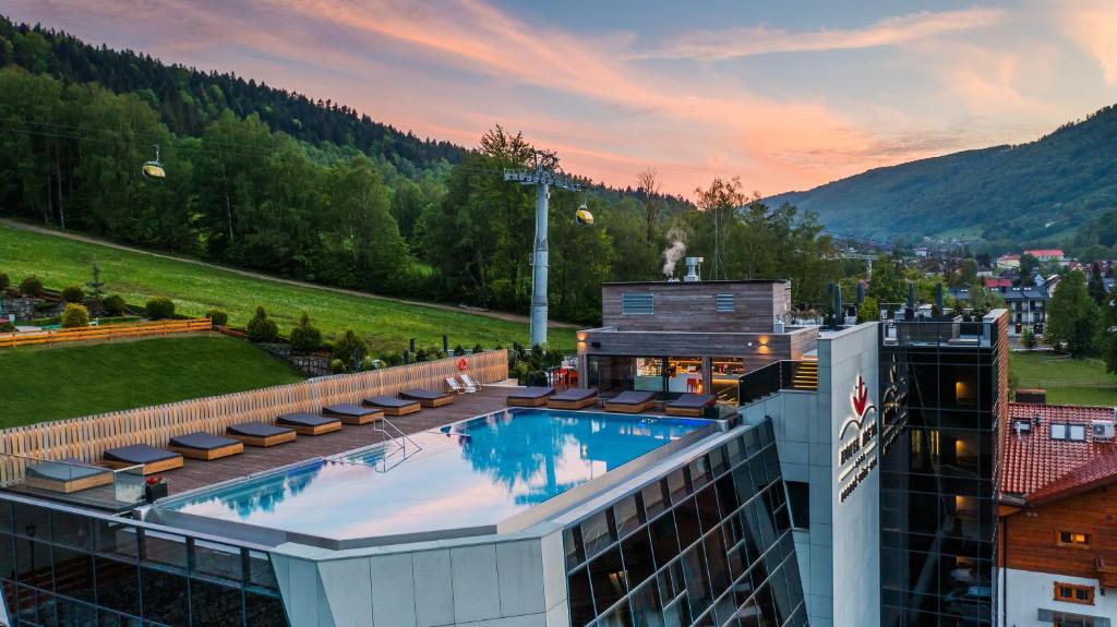 ein Hotel mit einem Pool auf einem Gebäude in der Unterkunft Hotel Meta Resort & Vine SPA in Szczyrk