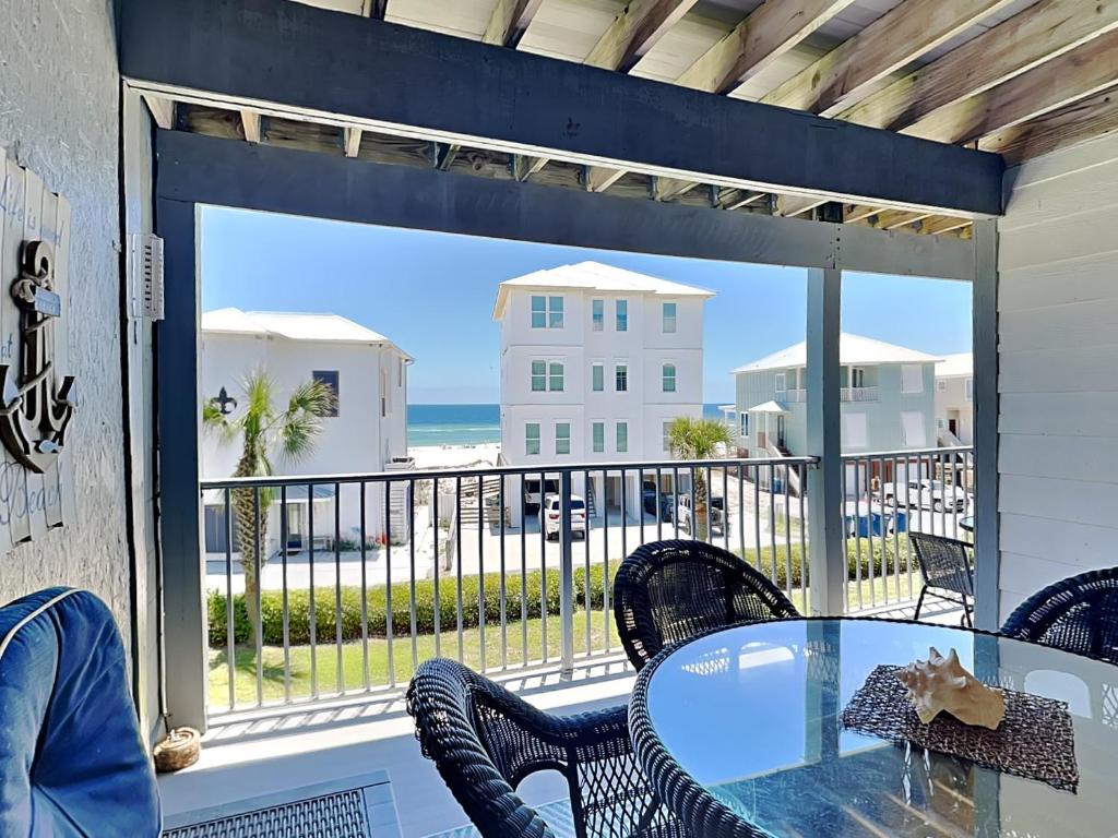 een patio met een tafel en stoelen en uitzicht op de oceaan bij Seascape 204 in Orange Beach
