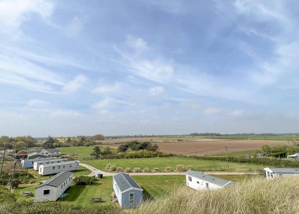 una vista de una granja con casas y un campo en Anchor Park en Happisburgh