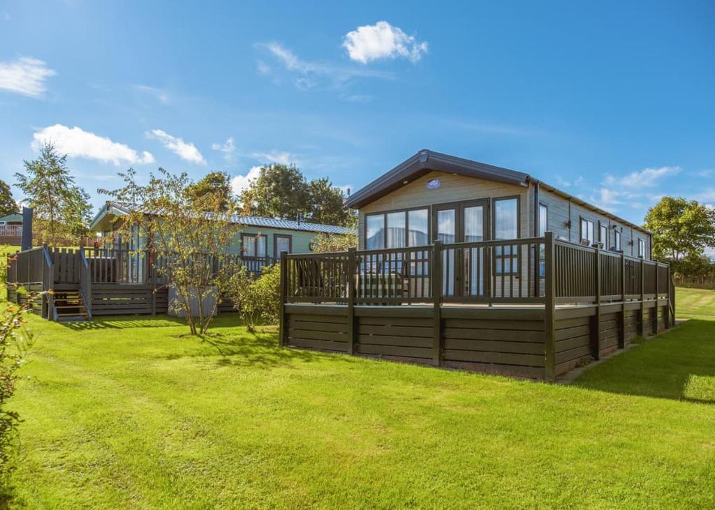 a large house with a large yard with grass at Docker Holiday Park in Carnforth