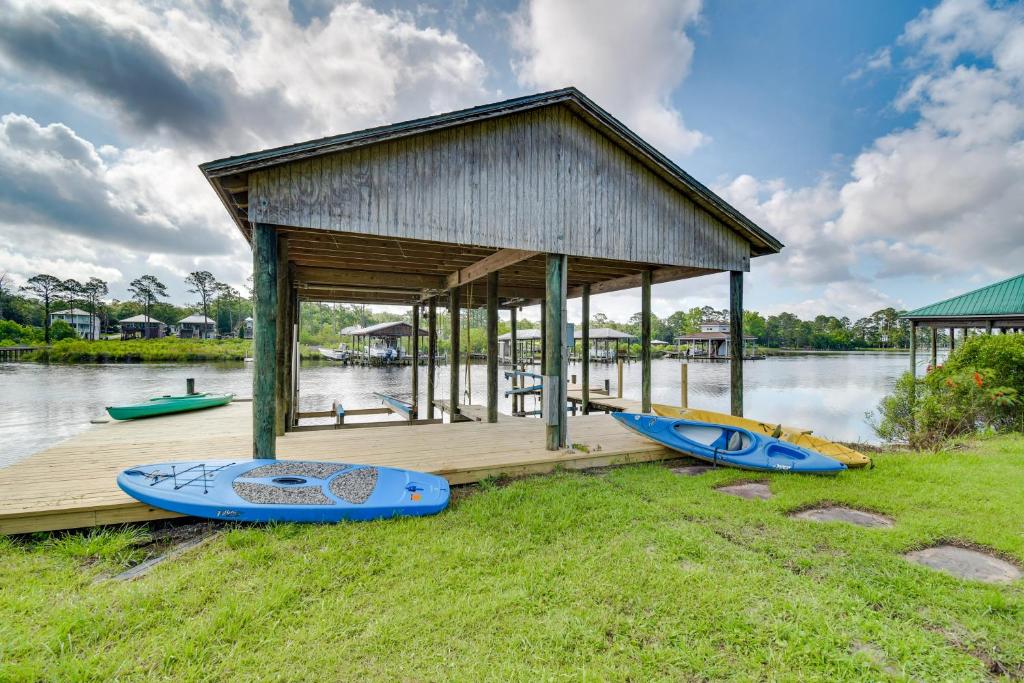 a small building with three kayaks parked next to a dock at Waterfront Wolf Bay Home with Private Boathouse! in Elberta