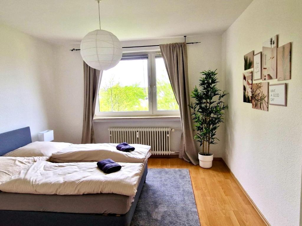 um quarto com 2 camas e uma janela em Komfortabel & Helles Apartment Nah am Flughafen, Frankfurt City, Wiesbaden und Rüsselsheim em Mörfelden-Walldorf