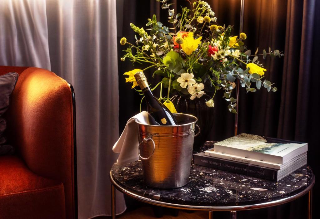 a table with a bucket with a champagne bottle and flowers at Hotel Hasselbacken in Stockholm
