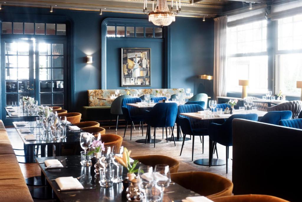 a dining room filled with tables and chairs at Hotel Hasselbacken in Stockholm