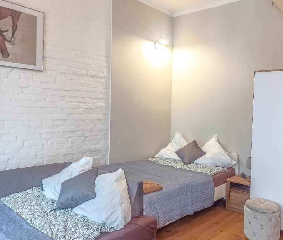 1 Schlafzimmer mit 2 Betten und Ziegelwand in der Unterkunft Mazurska Apartments in Stettin
