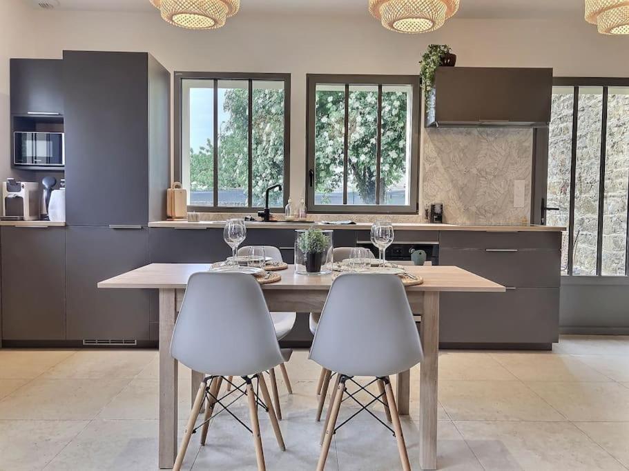 une cuisine avec une table en bois et deux chaises blanches dans l'établissement Charme et quiétude au coeur du quartier Tiret, à Ambérieu-en-Bugey