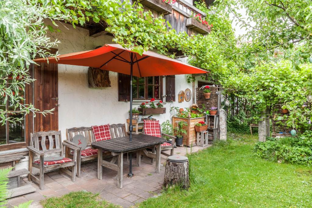 una mesa y sillas con sombrilla frente a una casa en Landhaus Lucia en Oberau