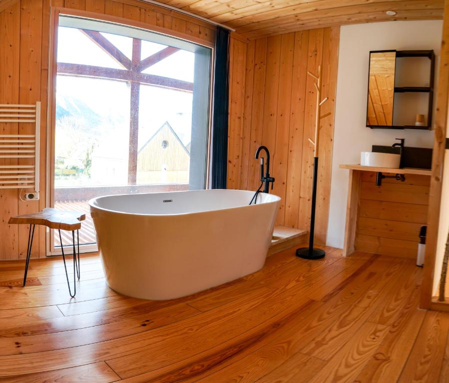 een groot bad in een kamer met een groot raam bij Le petit Repaire de Sailhan, Ecolodges in Sailhan