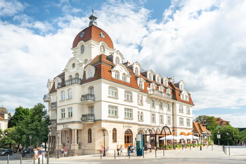 a large white building with a clock tower at Rezydent Sopot MGallery Hotel Collection in Sopot