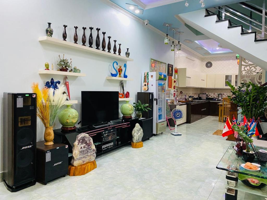 ein Wohnzimmer mit einem TV und ein Zimmer mit Vasen in der Unterkunft Cat Ba Central Homestay in Cát Bà