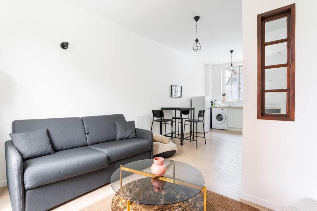un salon avec un canapé et une table dans l'établissement Appartement confortable et fonctionnel, à Lille