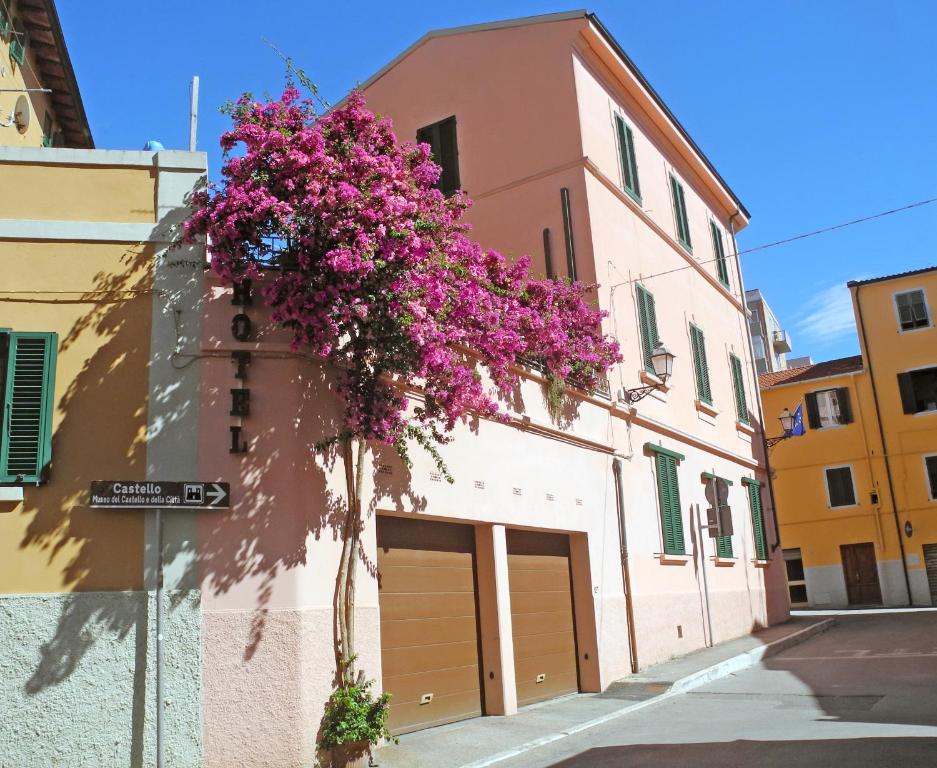 een gebouw met paarse bloemen aan de zijkant bij Albergo Italia in Piombino