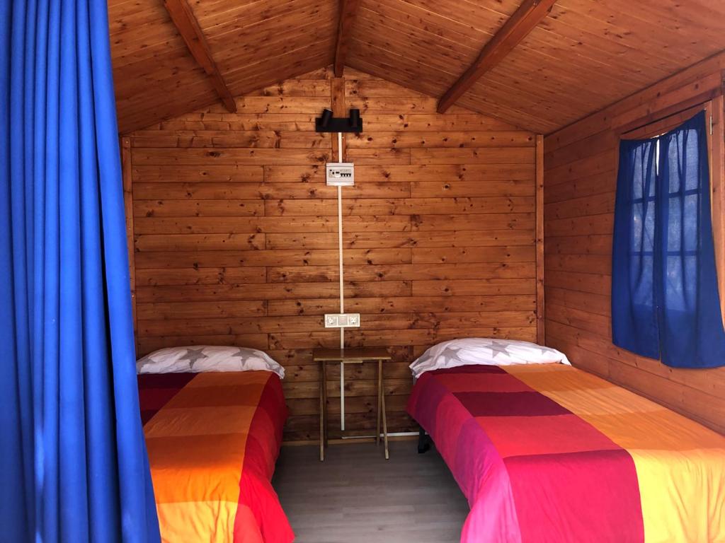 a room with two beds in a wooden cabin at Camping Santa Clara in Altea