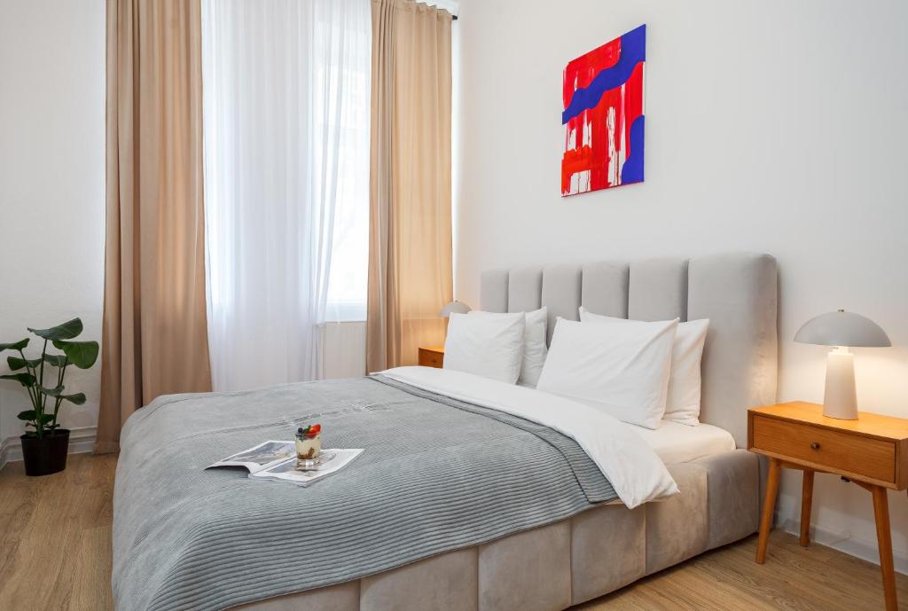 ein Schlafzimmer mit einem Bett, auf dem ein Tablett mit Essen steht in der Unterkunft oompH Berlin 3BR Apt with Light Tones and Artwork in Berlin