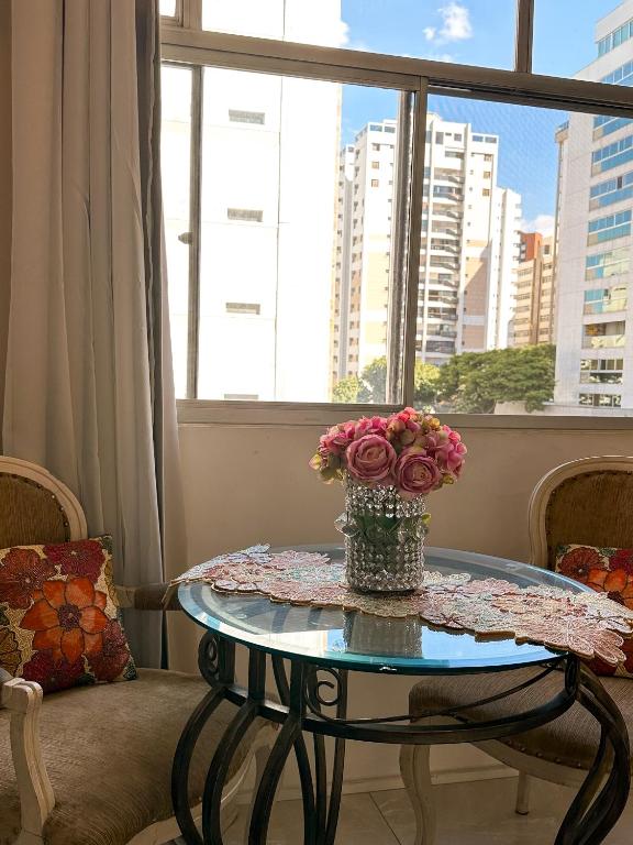 uma mesa de vidro com um vaso de flores em Apê Curitiba I Familiar, tranquilo e sossegado em Belo Horizonte