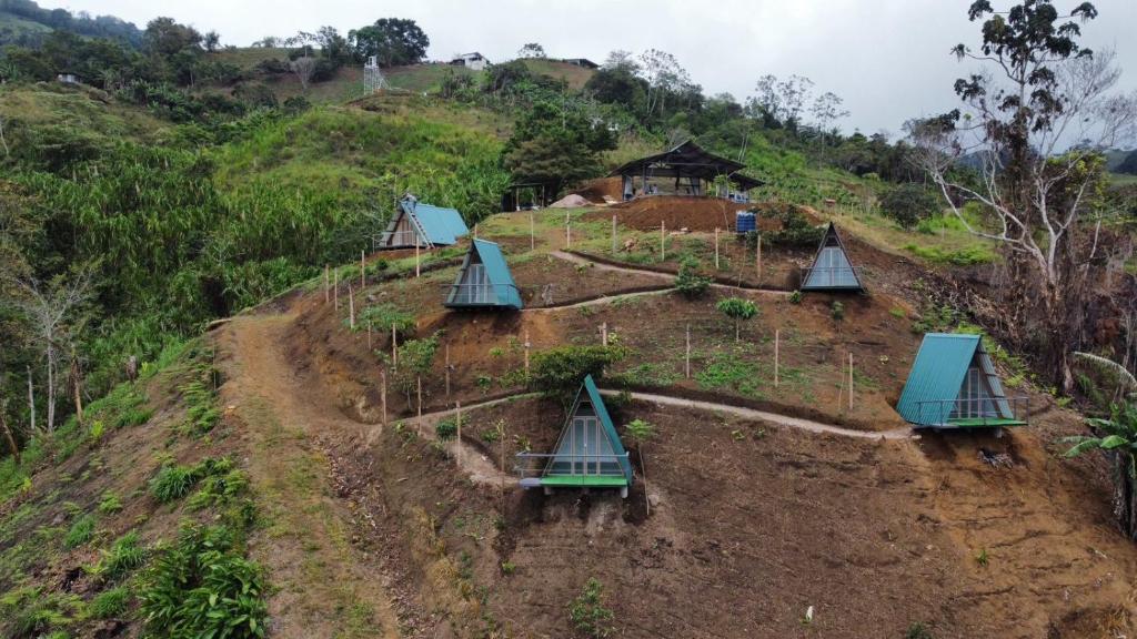 einen Bauernhof auf einem Hügel mit vier grünen Dächern in der Unterkunft Glamping La Mardo in Cartago
