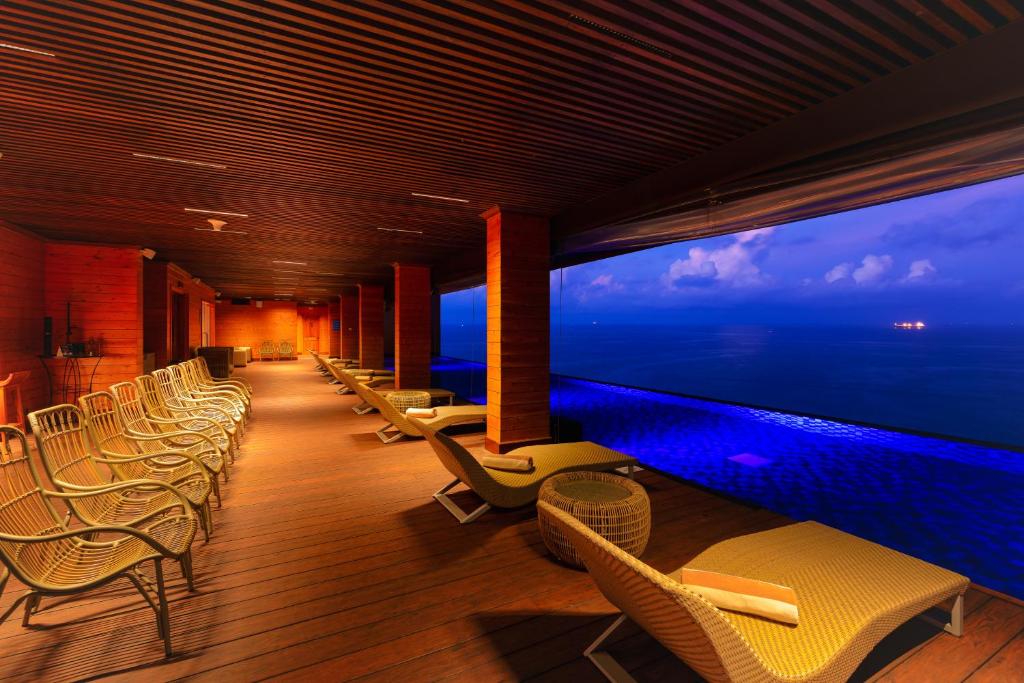 a room with chairs and a large window with the ocean at Araliya Beach Resort & Spa Unawatuna- Where you meet the sea all year in Unawatuna