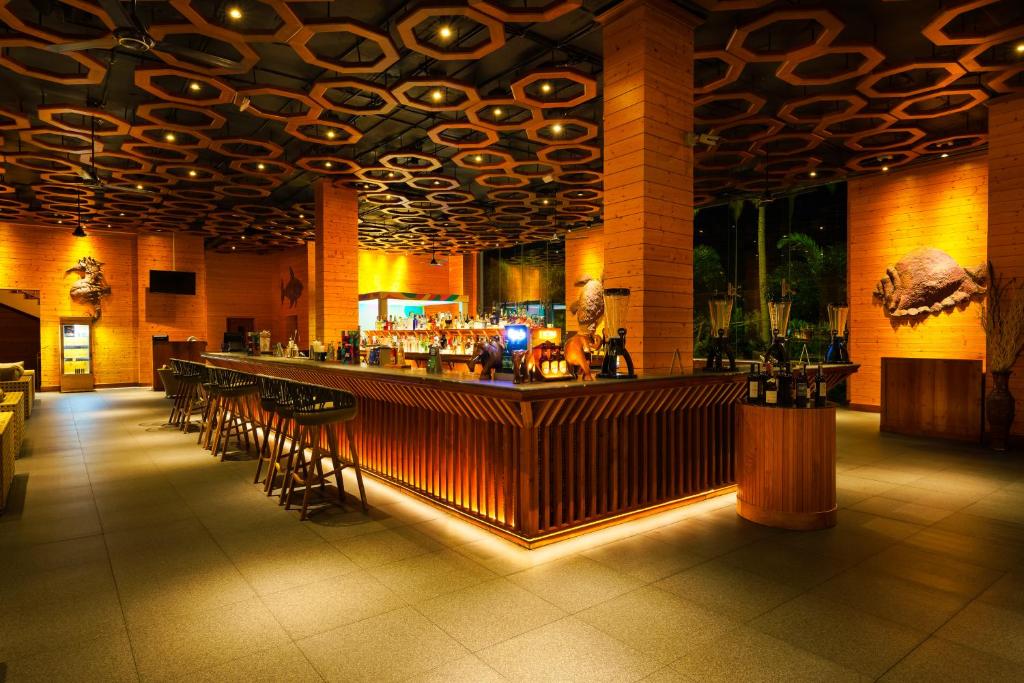 a bar in a building with a lot of bar stools at Araliya Beach Resort & Spa Unawatuna- Where you meet the sea all year in Unawatuna