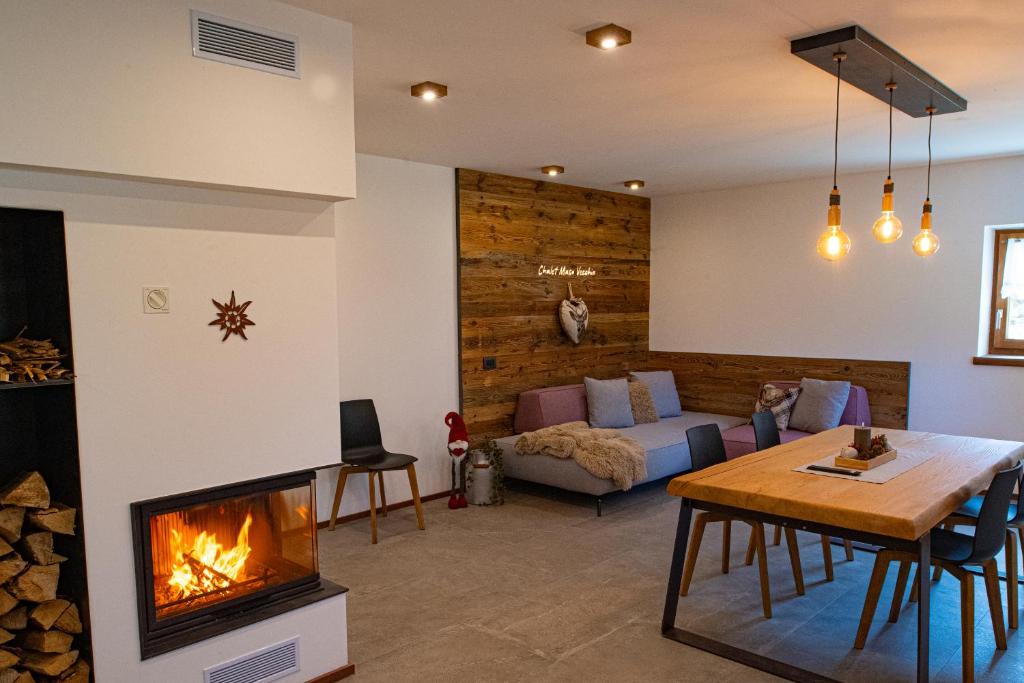 a living room with a fireplace and a couch at Chalet Aquila - Chalet Maso Vecchio fra le montagne del Trentino in Castello Tesino