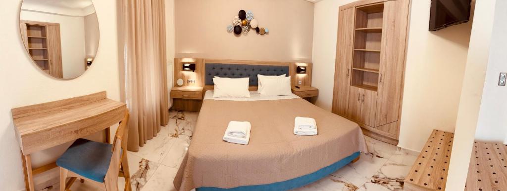 una camera da letto con un letto con asciugamani sopra di Marble House a Kavala