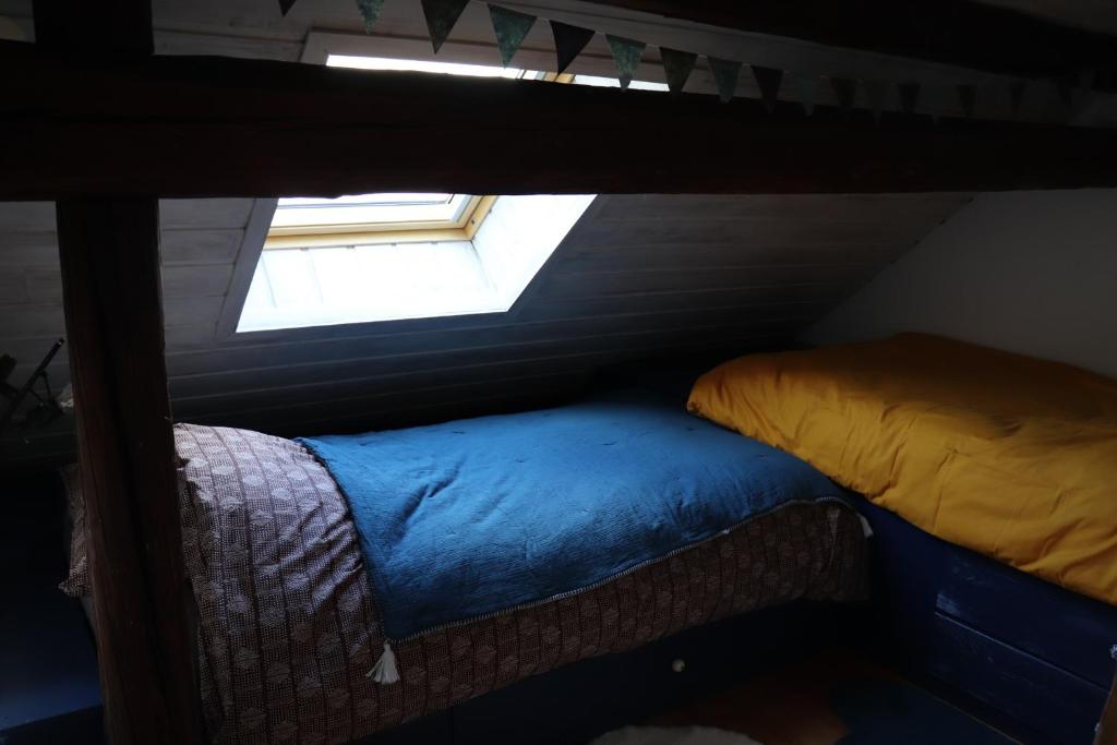 Cette chambre mansardée comprend 2 lits et une fenêtre. dans l&#39;établissement Appartement dans une maison de pays, à Briançon