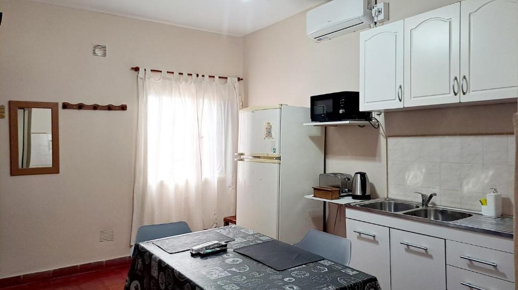 a small kitchen with a table and a refrigerator at Departamento Capital in San Fernando del Valle de Catamarca