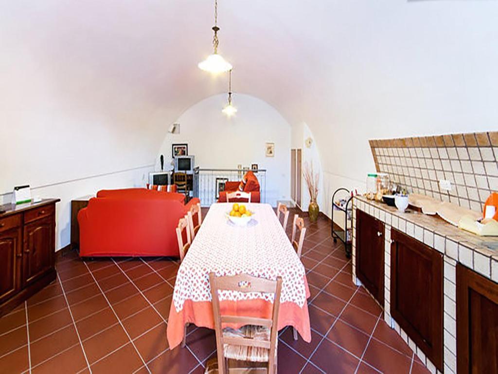 una cucina con tavolo e divano rosso di B&B San Rocco a Matera