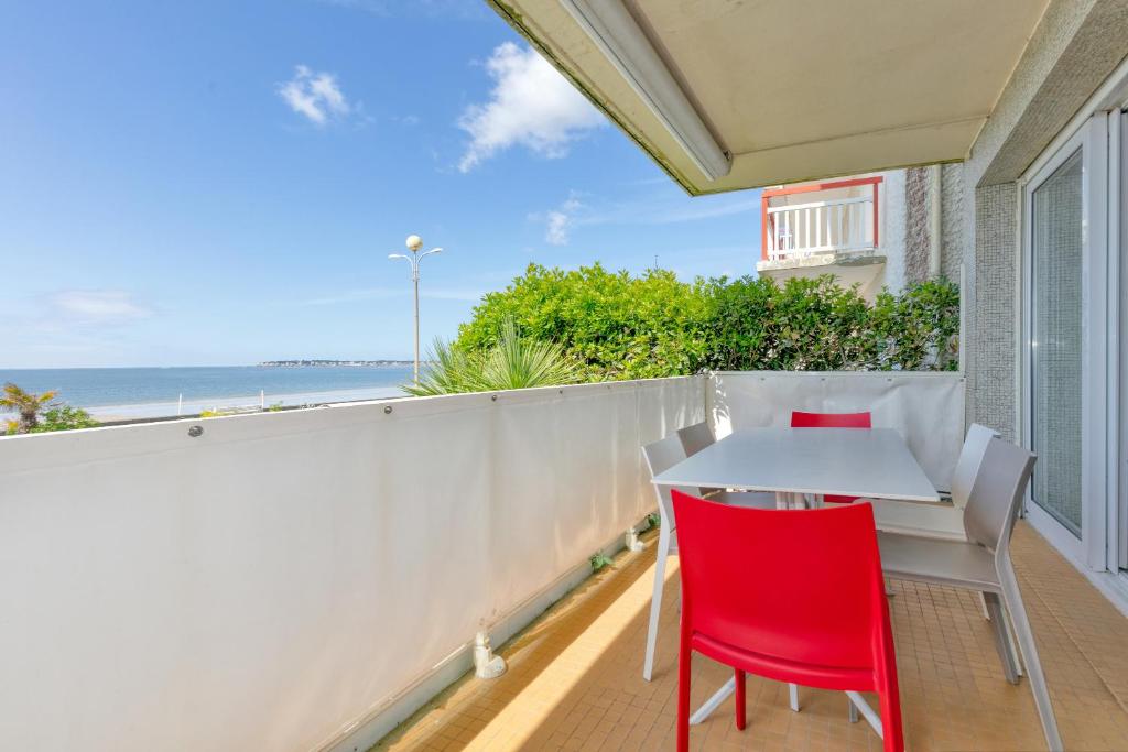 une table et des chaises sur un balcon avec vue sur l'océan dans l'établissement Appartement face mer sur plage, à La Baule