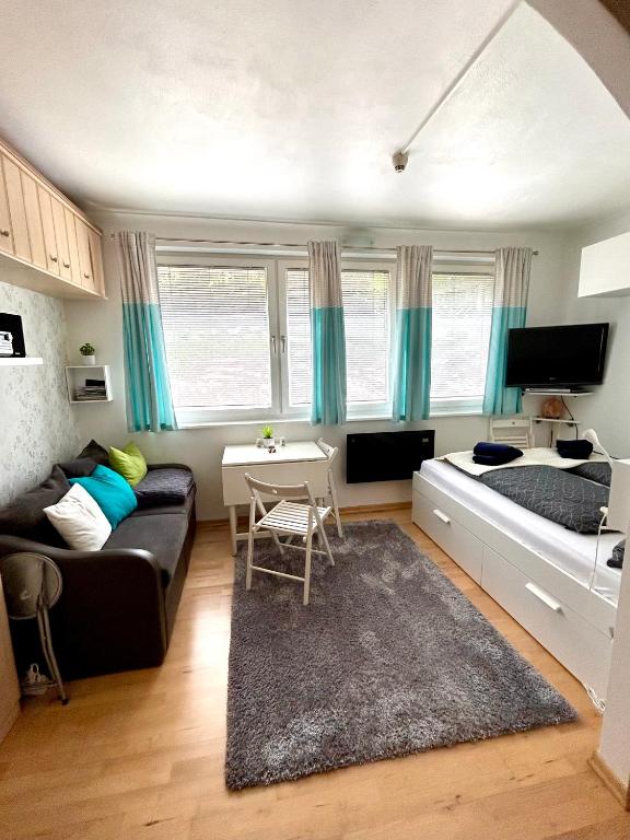 a living room with a couch and a bed at Apartment Schladming mit Sauna und Pool in Schladming