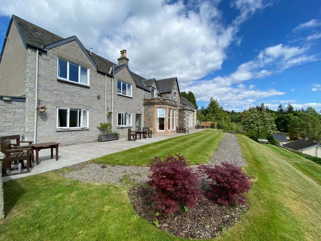 an external view of a house with a lawn at Beinn Bhracaigh in Pitlochry