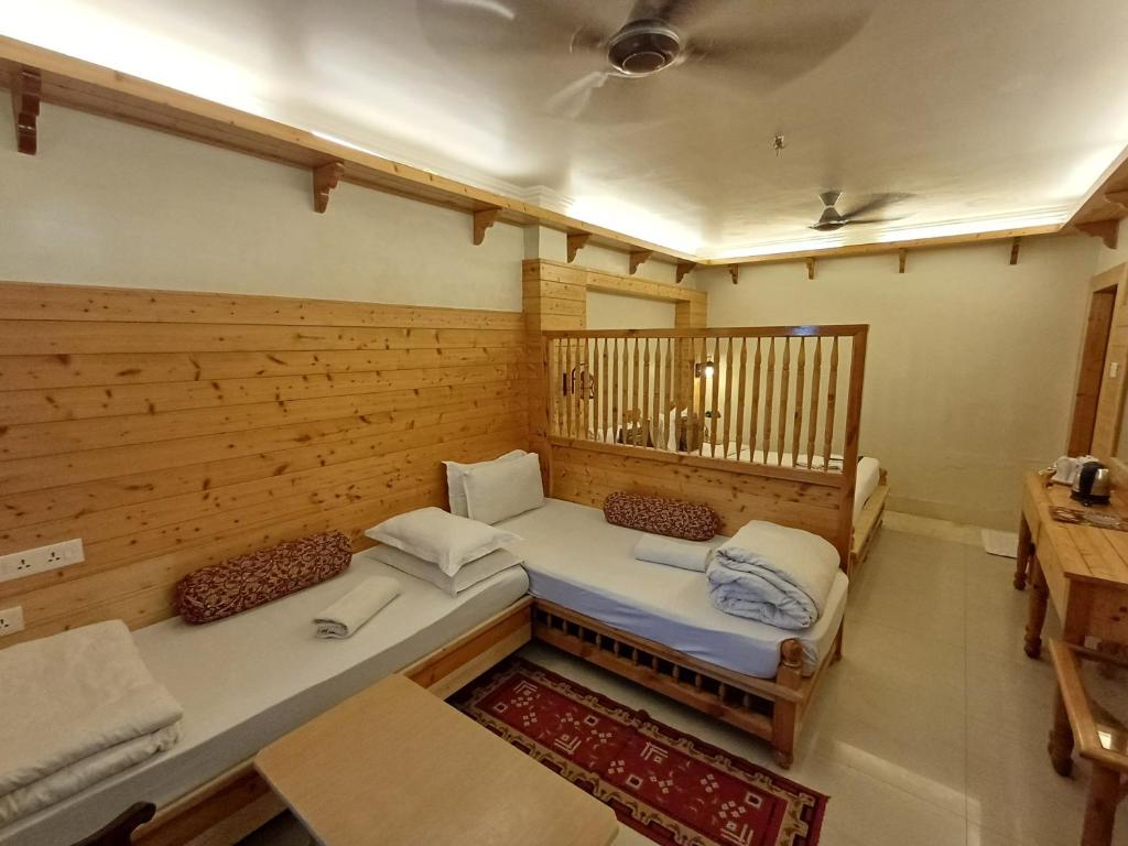 Habitación con 2 camas y pared de madera. en Hotel Temple On Ganges en Varanasi