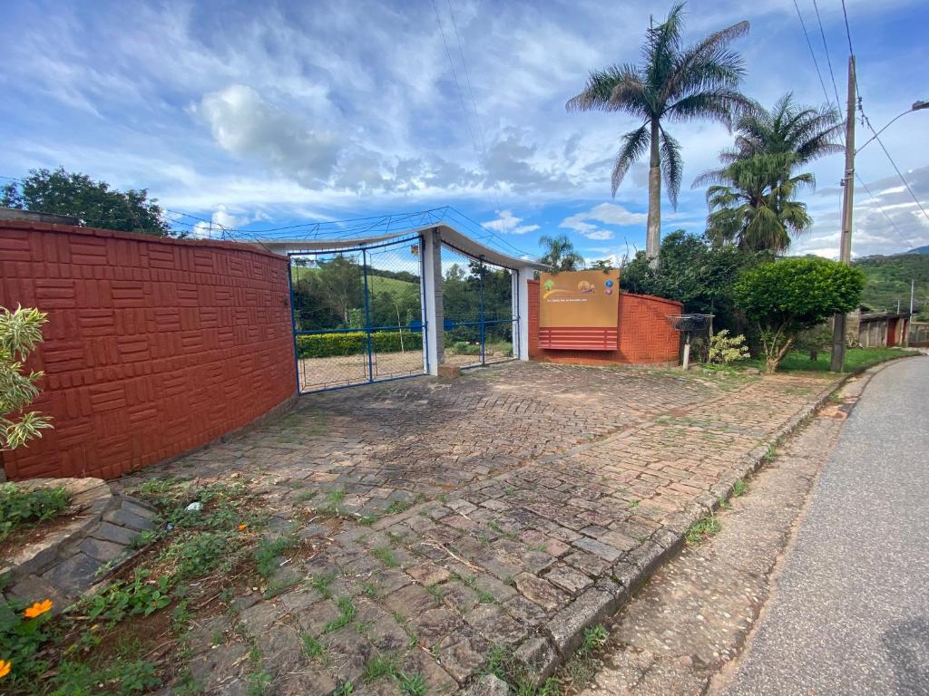una casa con una puerta y una valla en Pousada La na Roça, en Paraisópolis
