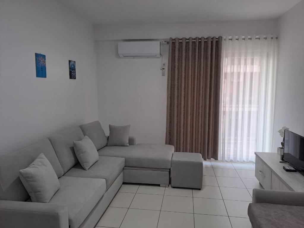 ein Wohnzimmer mit einem Sofa und einem TV in der Unterkunft SummerhouseVelipoje-Te Kompleksi Fishta-Q1,36 in Velipojë