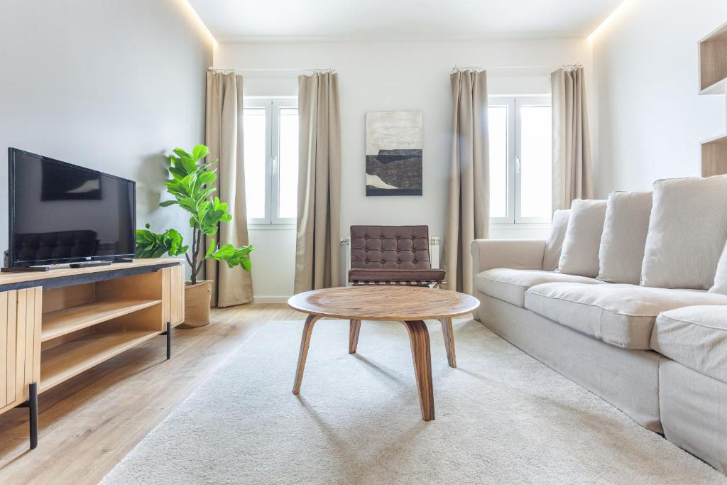 sala de estar con sofá blanco y mesa en Luces en Madrid, en Madrid