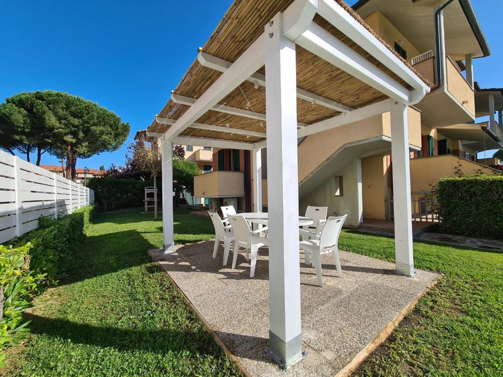 a patio with a table and chairs under a pergola at Villaggio Mietta in Castiglioncello