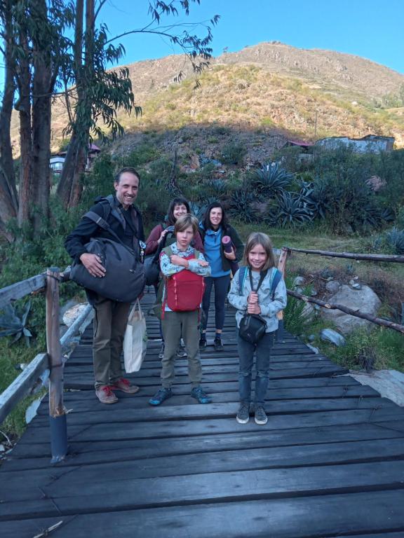 a group of people standing on a wooden bridge at casa montañista lodge & camping in Huaraz