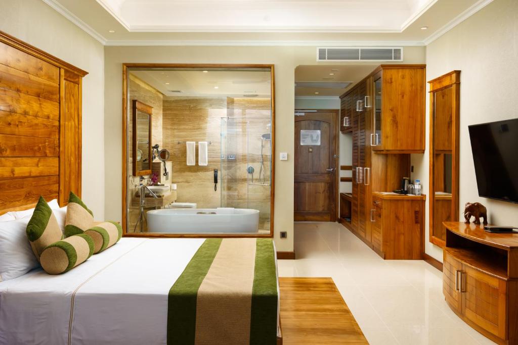 a bedroom with a large bed and a bathroom at Araliya Beach Resort & Spa Unawatuna- Where you meet the sea all year in Unawatuna