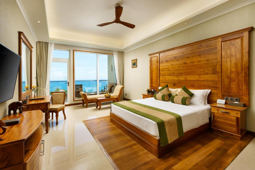 a bedroom with a bed and a desk and a television at Araliya Beach Resort & Spa Unawatuna- Where you meet the sea all year in Unawatuna