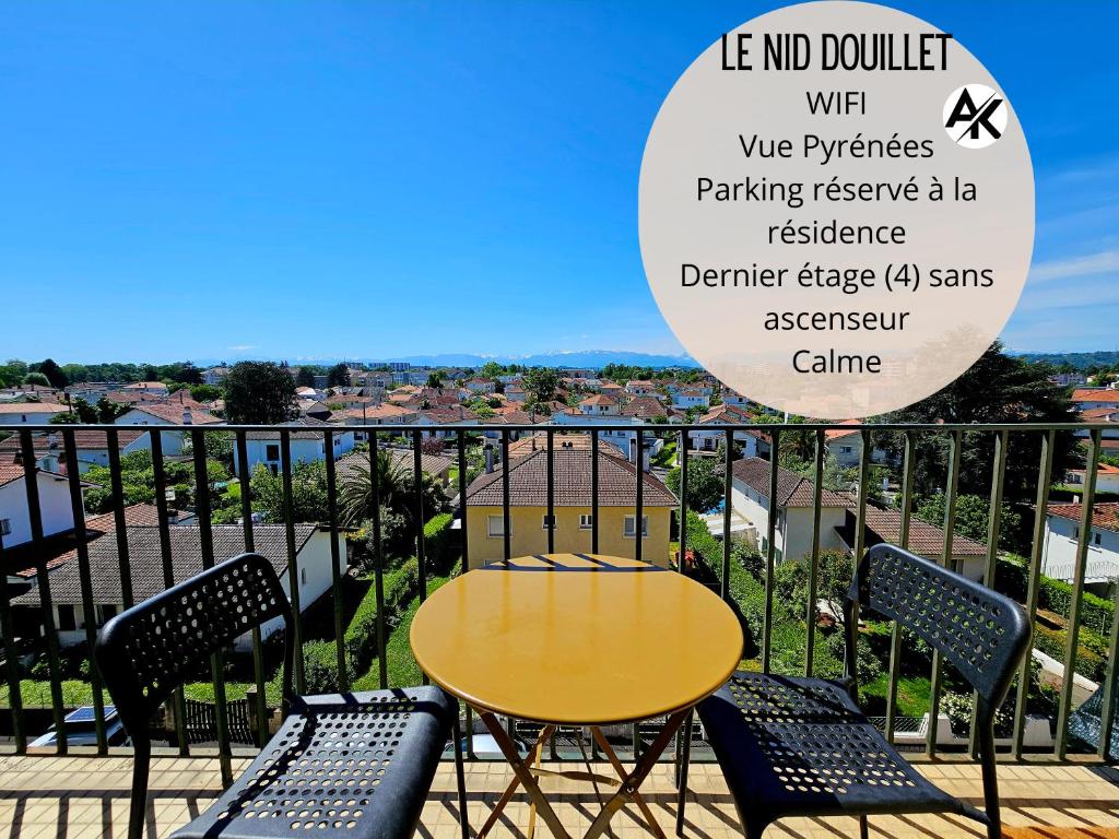 une table et des chaises jaunes sur un balcon dans l'établissement Nid douillet palois vue Pyrénées - Parking, à Pau
