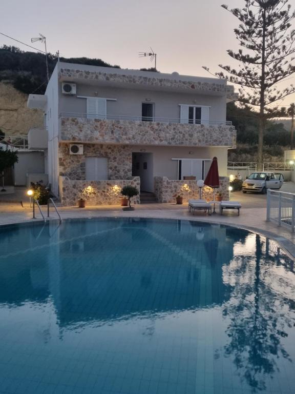 a large swimming pool in front of a house at Villa Popi Studios in Kefalos